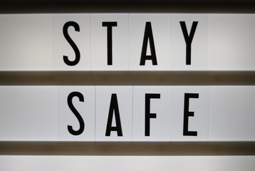 Lightbox sign saying Stay Safe written in black letters on white background