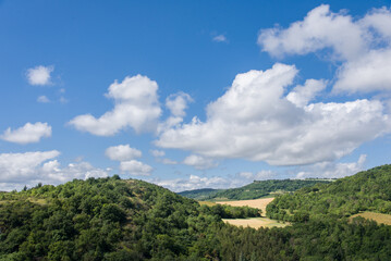 Fototapeta na wymiar un paysage rural. Un paysage de la campagne en France. Vue sur des champs et des collines boisées.