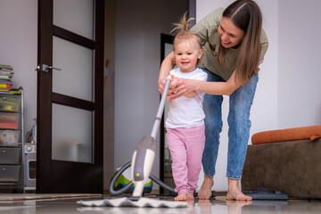 little daughter cleaning in the house, child dusting, Cute little helper girl washing floor with mop, happy family cleans the room.