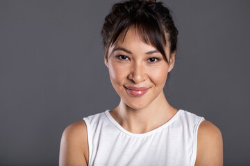 Studio shot of happy young asian woman smile with charming expression.
