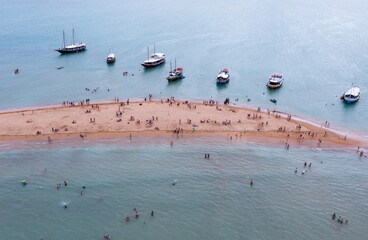 vista aérea da Coroa do Alto no litoral da Bahia. Pequenas embarcações transportando turistas para mergulho.