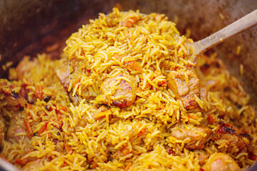 Preparation of pilaf dish close-up. Pilaf cooked on a fire.
