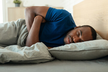 Obraz na płótnie Canvas African American Male Sleeping Lying In Bed At Home