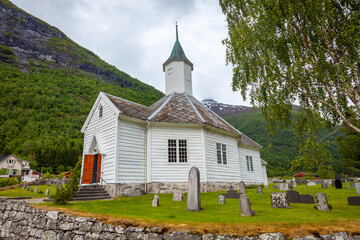 Fototapeta na wymiar Bakka wooden catholic Church and tombstones in Aurland, Norway