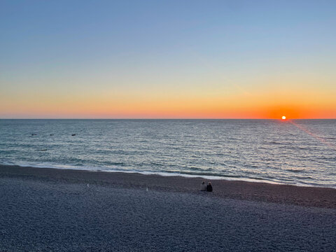 Beautiful sunset or sunrise iver the sea. Colorful cloud band above the horizon.