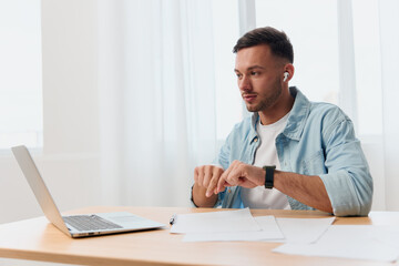 Concentrated pensive good-looking young businessman meeting using laptop app video conference communication in office. Copy space for ad. Remote Job, Technology And Career Profession Concept