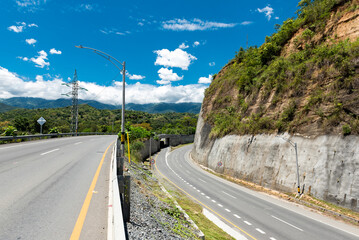 Antioquia, Colombia - Double carriageway west of the department. Landscapes with dual carriageway, mountains and blue sky - obrazy, fototapety, plakaty
