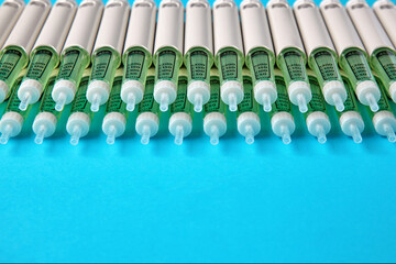 Diabetic insulin pens lined up on a blue background. Volunteer movement for the provision of medicines to patients with diabetes mellitus