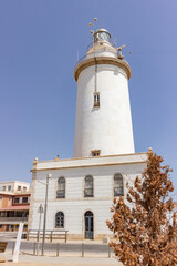Malaga lighthouse in the foreground with blue sky in the marina