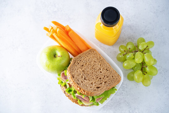 Healthy school lunch with a sandwich, fresh fruits and juice - Powered by Adobe