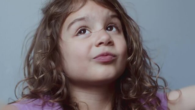 Portrait of a cute toddler girl making funny faces. 4K footage.