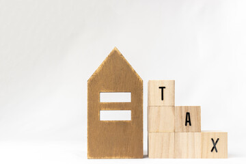 木のブロックのTAXと、玩具の家。税金が減るイメージ