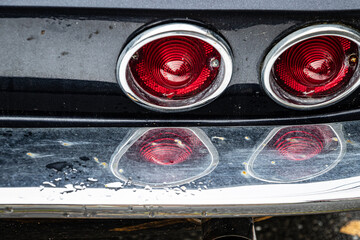 Antique Car Tail Lights with water in the chrome reflection