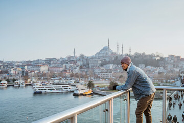 Naklejka premium man standing on the bridge while enjoying the view of bosphorus istanbul turkey