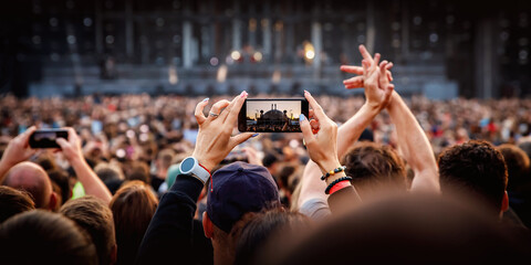 Fototapeta na wymiar People holding their smartphones at concert and taking pictures.