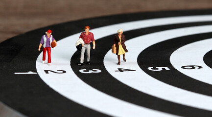 Miniature people walking on the target. A business concept for a competitive society.
