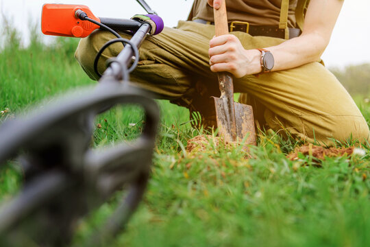 metal detector at work in the forest or field. Search for treasure and ancient values. Archeology. Man with a metal detector. Military sapper