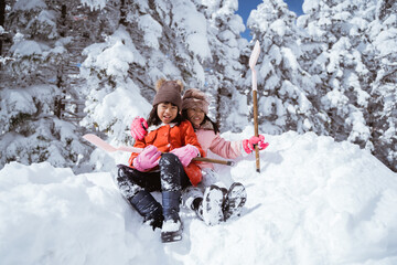 two girl playing with snow. asian little sister enjoy their time in snowy winter together