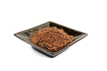 Ground dried sumac berry powder on a black ceramic plate