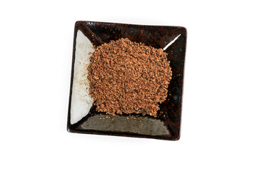 Ground dried sumac berry powder in a black ceramic plate top down