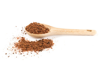 Ground dried sumac berry powder in a wood measuring spoon some spilled