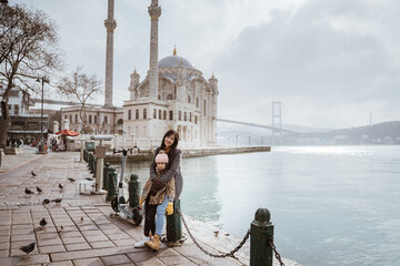 Obraz premium mother and daughter portrait in front of ortakoy mosque in istanbul turkiye