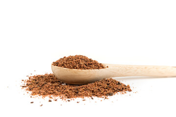 Ground dried sumac berry powder in a wood measuring spoon side view close up
