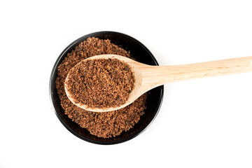 Ground dried sumac berry powder in a black bowl and a wooden scoop