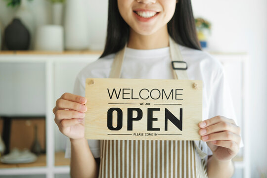 Young asian business owner turning open sign product store and ready to service for welcome the customer.