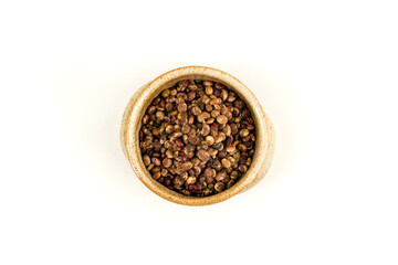 Whole dried sumac berries in a small earthenware bowl over white top down