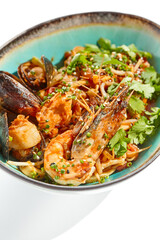 Japanese soba with seafood cooked on wok in asian style on white background. Noodle seafood in ceramic bowl. Indonesian wok with prawn, mussels and soba noodles. Spicy thai dish with shrimp and udon.