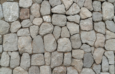 Neatly stacked rough cut stone wall seamless texture background.