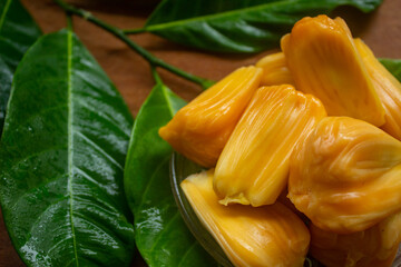 peeled jackfruit with jackfruit leaf background and wood pattern as the base