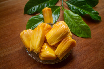 peeled jackfruit with jackfruit leaf background and wood pattern as the base