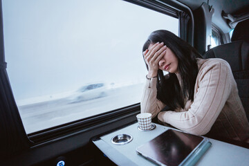 frustrated asian young woman while sitting inside a car or a van with big window