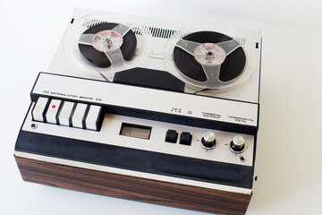 old-style reel-to-reel tape recorder, with inscriptions (record, stop, play, volume, network, level,) selective focus, close-up on a white background