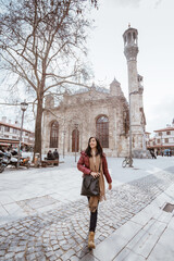 asian woman walking in the square with aziziye mosque at the background