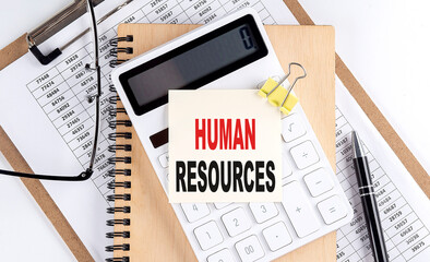 HUMAN RESOURCES word on sticky with clipboard and notebook, business concept