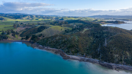 Obraz na płótnie Canvas Aerial View of Waitawa Regional Park, Beach, Pier, Deck Green Trees and Cliff in New Zealand - Auckland Area