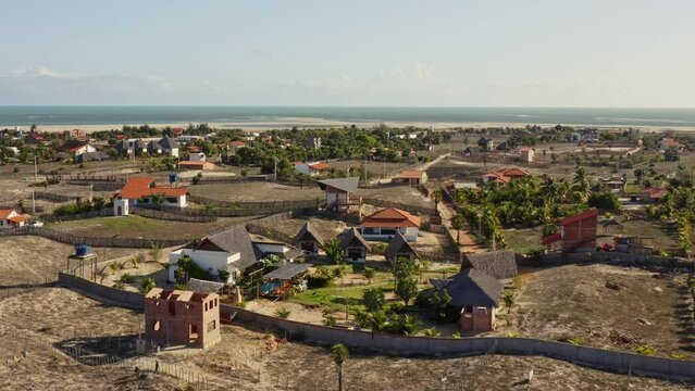 Drone crane motion toward lush Brazilian hotel resort garden with small lodges