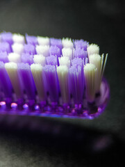 Close-up of white and purple toothbrush bristles on a dark background