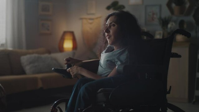 Calm and happy woman with spinal muscular atrophy enering the dim room illuminated by a warm lamp sitting in a motorized wheelchair and smiling