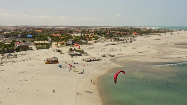 Multiple kite surfers ride close together in shallow narrow Macapa beach pond