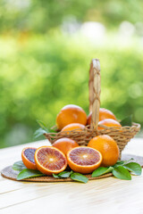 Blood oranges, or Red oranges with leaf bamboo basket on green bokeh background. 