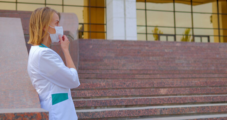 Portrait of woman doctor wearing protective medical face mask and sad looking.