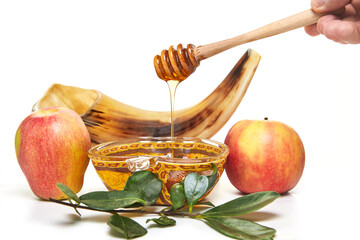 Rosh hashanah - jewish new year holiday concept. An apple-shaped bowl with honey, apples, a shofar...
