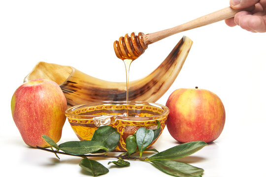Rosh hashanah - jewish new year holiday concept. An apple-shaped bowl with honey, apples, a shofar are traditional symbols of the holiday. Isolated on white background