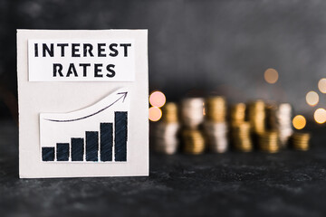 interest rates text and graph showing stats going up in front of stacks on coins and lights, global economy after the covid-19 pandemic