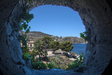 View from a ivy-covered castle window onto Lipari harbour and sea