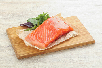 Raw salmon fillet over board
